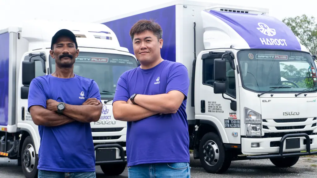 Two Haroct team members standing in front of a Haroct delivery truck