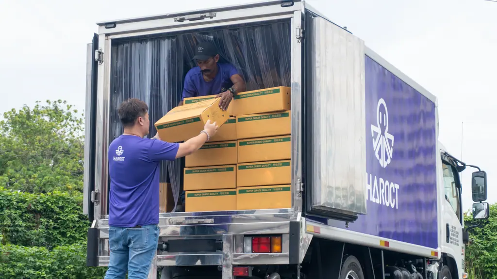 A Haroct team member loading crates into a Haroct refrigerated truck